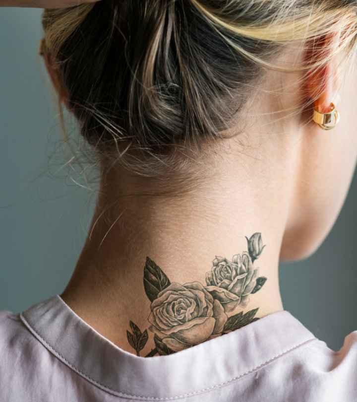 A woman holds up her hair to flaunt a beautifully healed tattoo on the nape of her neck.