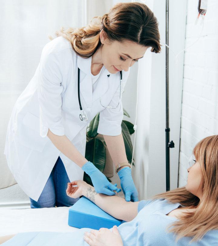 A doctor holding a patient’s arm to get her ready for blood donation