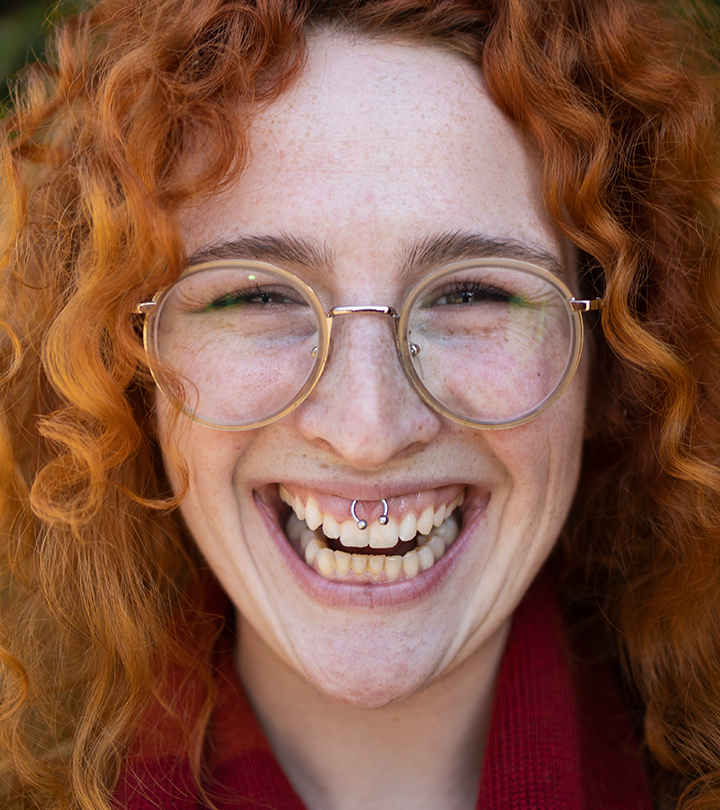 Close-up of a happy woman with a smiley piercing