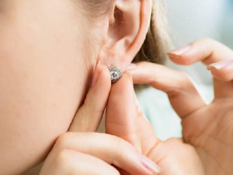 A woman changing her ear piercing jewelry