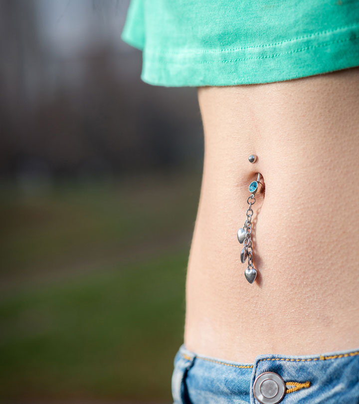 Close up of a belly button piercing