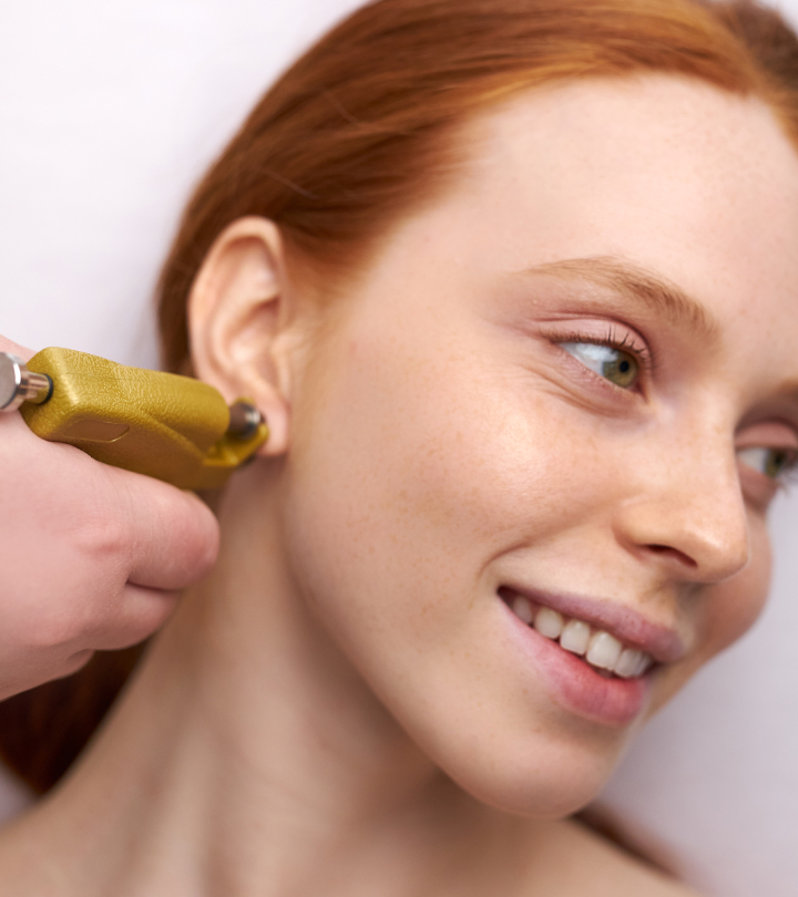 Woman getting a transverse lobe piercing