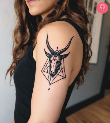 Woman with a Baphomet head tattoo on the upper arm