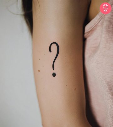 A question mark tattoo on the arm of a woman