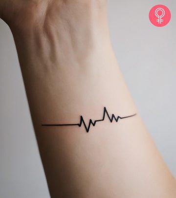 A woman wearing a cat heartbeat tattoo on her forearm. A woman wearing a cat heartbeat tattoo on her forearm.
