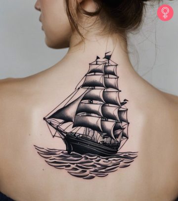Travel tattoo of a sailing ship on a girl’s back
