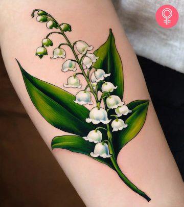 A woman with a lily of the valley tattoo on her forearm