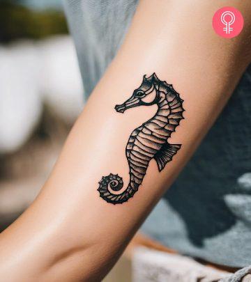 Woman with a seahorse tattoo on her arm. Woman with a seahorse tattoo on her arm.