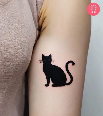 A black cat tattoo on a woman’s arm