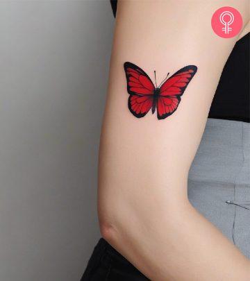A woman with a red butterfly tattoo on her upper arm A woman with a red butterfly tattoo on her upper arm