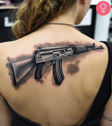 An AK-47 tattooed on the upper back An AK-47 tattooed on the upper back