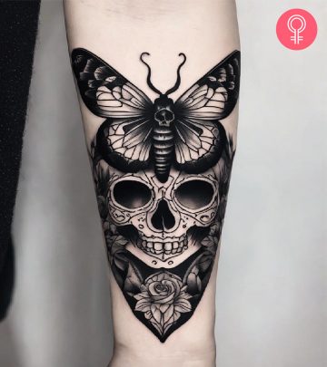 A woman with a black death moth tattoo on her forearm