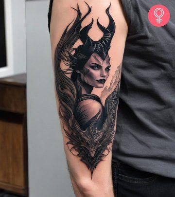 A man wearing a Maleficent dragon tattoo on his upper arm.
