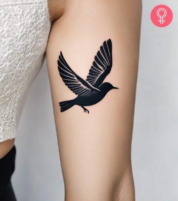 A woman with a freedom tattoo on the upper arm A woman with a freedom tattoo on the upper arm