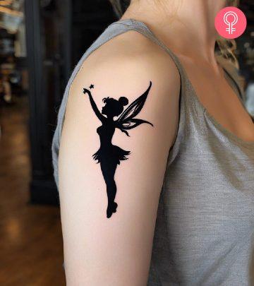Tinkerbell tattoo on a woman’s upper arm Tinkerbell tattoo on a woman’s upper arm