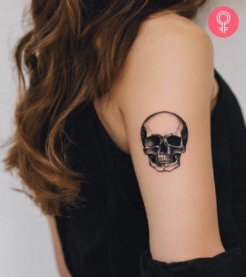 Woman with skull tattoo on her upper arm Woman with skull tattoo on her upper arm