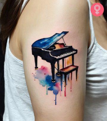 A piano tattoo on a woman’s upper arm A piano tattoo on a woman’s upper arm