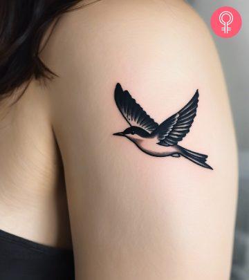 A flying bird tattoo on the upper arm A flying bird tattoo on the upper arm