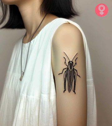 A grasshopper tattoo on the upper arm of a woman A grasshopper tattoo on the upper arm of a woman
