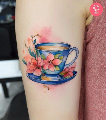 A teacup tattoo on a woman’s upper arm A teacup tattoo on a woman’s upper arm