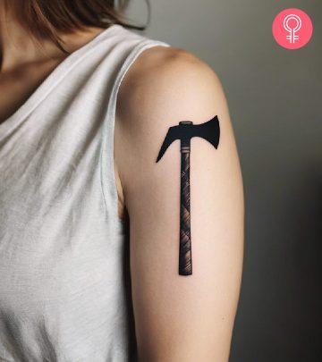 An axe tattoo on a woman’s arm An axe tattoo on a woman’s arm