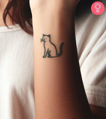 An aged cat tattoo on the wrist An aged cat tattoo on the wrist