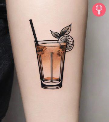 A sepia-tone orange cocktail with an orange wedge on the forearm. A sepia-tone orange cocktail with an orange wedge on the forearm.