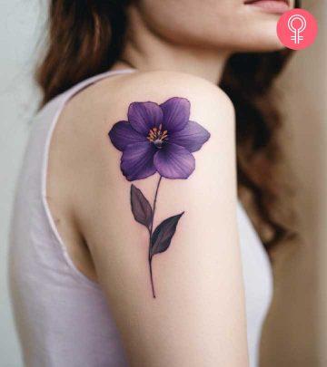 A woman wearing a violet flower tattoo on her upper arm A woman wearing a violet flower tattoo on her upper arm