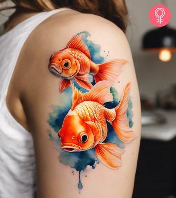 A goldfish tattoo on a woman’s shoulder A goldfish tattoo on a woman’s shoulder