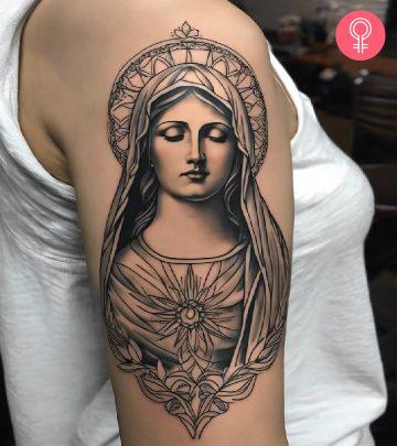 Woman with a black and gray portrait tattoo of the Virgin Mary on the upper arm Woman with a black and gray portrait tattoo of the Virgin Mary on the upper arm