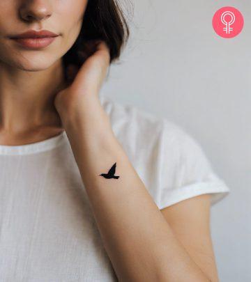 A woman flaunting a blackbird tattoo on her wrist A woman flaunting a blackbird tattoo on her wrist