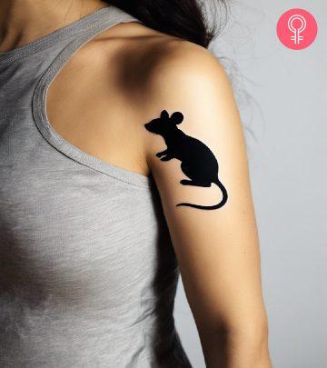 A woman wearing a ‘minimalist mouse’ tattoo on the upper arm. A woman wearing a ‘minimalist mouse’ tattoo on the upper arm.