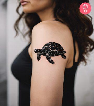 A woman with black tortoise tattoo on her upper arm A woman with black tortoise tattoo on her upper arm