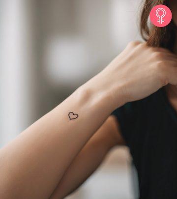 A woman with a simple heart tattoo on her wrist A woman with a simple heart tattoo on her wrist