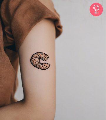 Woman with croissant tattoo on her arm Woman with croissant tattoo on her arm